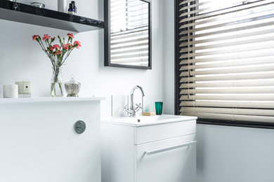 Cette image montre une petite salle d'eau design avec un lavabo suspendu, une douche d'angle, WC à poser, un carrelage blanc, des carreaux de céramique, un mur blanc et un sol en vinyl.