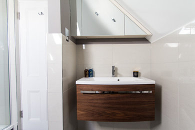 Kleines Modernes Duschbad mit Einbauwaschbecken, flächenbündigen Schrankfronten, hellbraunen Holzschränken, offener Dusche, Toilette mit Aufsatzspülkasten, beiger Wandfarbe und Keramikboden in London