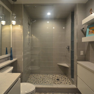 Exempel på ett litet modernt vit vitt en-suite badrum, med släta luckor, vita skåp, en dusch i en alkov, en toalettstol med separat cisternkåpa, grå kakel, porslinskakel, grå väggar, klinkergolv i småsten, ett undermonterad handfat, granitbänkskiva, flerfärgat golv och med dusch som är öppen