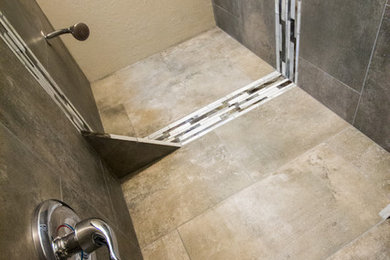 Kleines Modernes Duschbad mit Duschnische, Wandtoilette mit Spülkasten, grauen Fliesen, weißer Wandfarbe und braunem Holzboden in Sonstige
