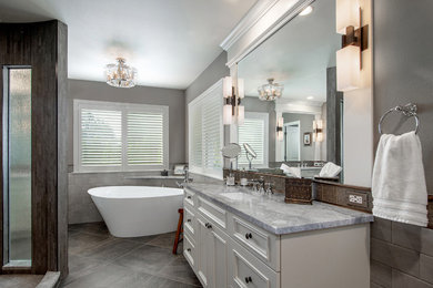 Exempel på ett stort klassiskt grå grått en-suite badrum, med möbel-liknande, vita skåp, ett fristående badkar, en öppen dusch, en toalettstol med separat cisternkåpa, grå kakel, keramikplattor, grå väggar, klinkergolv i porslin, ett undermonterad handfat, bänkskiva i kvartsit, grått golv och med dusch som är öppen