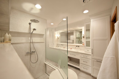 Alcove shower - large contemporary master white tile and ceramic tile ceramic tile and gray floor alcove shower idea in St Louis with shaker cabinets, white cabinets, a two-piece toilet, white walls, a vessel sink, solid surface countertops and a hinged shower door