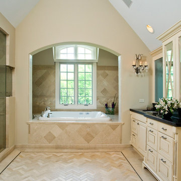 Soaking tub set in curved alcove with his and her sinks