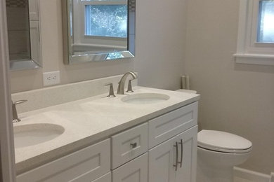 Example of a small transitional master gray tile and porcelain tile porcelain tile and gray floor bathroom design in Indianapolis with shaker cabinets, white cabinets, a two-piece toilet, gray walls, an undermount sink and quartz countertops