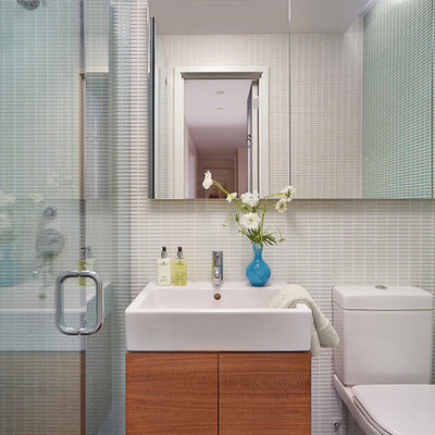 Alcove shower - mid-sized contemporary 3/4 ceramic tile and black floor alcove shower idea in New York with flat-panel cabinets, medium tone wood cabinets, a two-piece toilet, a wall-mount sink and a hinged shower door