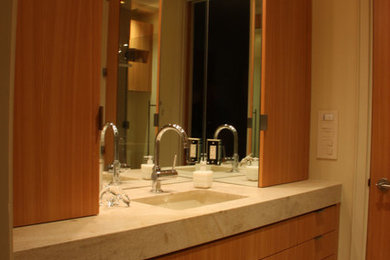 サンディエゴにあるコンテンポラリースタイルのおしゃれなバスルーム (浴槽なし) (フラットパネル扉のキャビネット、茶色いキャビネット、ベージュのタイル、アンダーカウンター洗面器、大理石の洗面台、ダブルシャワー、壁掛け式トイレ、ベージュの壁、セラミックタイルの床、開き戸のシャワー) の写真
