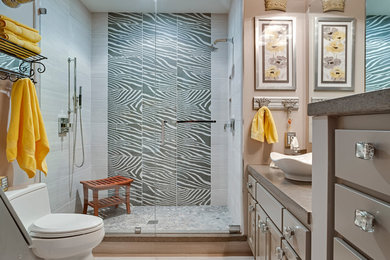 Corner shower - large eclectic master porcelain tile porcelain tile corner shower idea in Minneapolis with beaded inset cabinets, gray cabinets, a one-piece toilet, beige walls, a vessel sink and solid surface countertops
