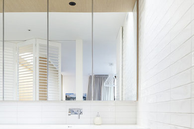 Modelo de cuarto de baño actual grande con puertas de armario de madera clara
