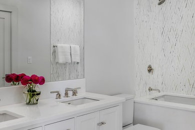 Mid-sized trendy master white tile beige floor bathroom photo in Boston with shaker cabinets, white cabinets, a one-piece toilet, white walls, an undermount sink, quartz countertops and white countertops