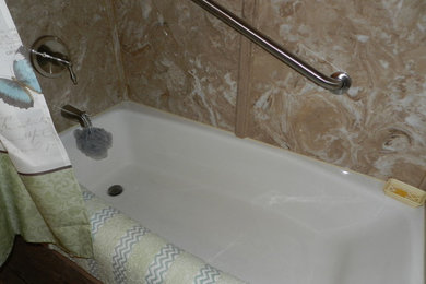 Bild på ett mellanstort lantligt en-suite badrum, med ett undermonterad handfat, skåp i shakerstil, vita skåp, bänkskiva i kvarts, ett badkar i en alkov, en dusch/badkar-kombination, en toalettstol med separat cisternkåpa, brun kakel, stenhäll, beige väggar och vinylgolv