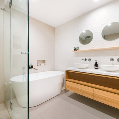 Mid-sized trendy master beige tile and porcelain tile porcelain tile and beige floor bathroom photo in Melbourne with flat-panel cabinets, beige cabinets, white walls, a vessel sink and white countertops