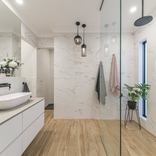 Large contemporary bathroom in Perth with white cabinets, an open shower, ceramic tile, ceramic floors, a vessel sink, solid surface benchtops, an open shower, flat-panel cabinets, white tile, white walls, beige floor and beige benchtops.