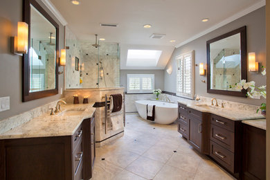 Mid-sized trendy beige tile and stone tile porcelain tile bathroom photo in Portland with an undermount sink, recessed-panel cabinets, dark wood cabinets, granite countertops, a two-piece toilet and gray walls
