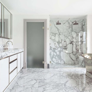 This is an example of a classic ensuite bathroom in Oxfordshire with flat-panel cabinets, white cabinets, a freestanding bath, a built-in shower, grey tiles, white walls, a submerged sink, grey floors, a hinged door and grey worktops.