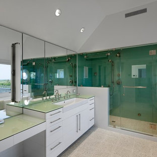 Inspiration för ett mycket stort amerikanskt en-suite badrum, med släta luckor, vita skåp, ett fristående badkar, en dusch i en alkov, en toalettstol med separat cisternkåpa, grå kakel, spegel istället för kakel, vita väggar, vinylgolv, ett avlångt handfat, bänkskiva i glas, vitt golv och dusch med gångjärnsdörr
