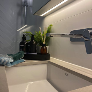 Bild på ett litet funkis grå grått en-suite badrum, med luckor med profilerade fronter, grå skåp, våtrum, en toalettstol med hel cisternkåpa, vit kakel, keramikplattor, vita väggar, klinkergolv i keramik, ett undermonterad handfat, bänkskiva i kvarts, grått golv och dusch med gångjärnsdörr