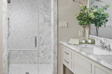 Idéer för att renovera ett stort vintage en-suite badrum, med en dusch i en alkov, beige skåp, grå kakel, vit kakel, beige väggar, klinkergolv i porslin, ett undermonterad handfat, marmorbänkskiva, marmorkakel, beiget golv, dusch med gångjärnsdörr och luckor med infälld panel