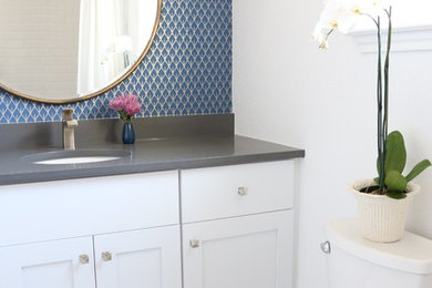 Example of a small transitional 3/4 white tile and porcelain tile porcelain tile corner bathtub design in Austin with shaker cabinets, white cabinets, a one-piece toilet, white walls, a console sink and quartz countertops