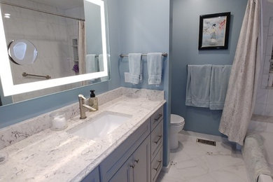 На фото: маленькая главная ванная комната в стиле неоклассика (современная классика) с фасадами с утопленной филенкой, серыми фасадами, накладной ванной, душем над ванной, унитазом-моноблоком, белой плиткой, керамической плиткой, синими стенами, полом из керамической плитки, врезной раковиной, столешницей из искусственного кварца, белым полом, шторкой для ванной и разноцветной столешницей для на участке и в саду