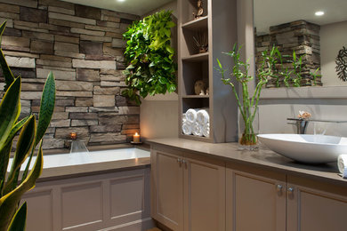 Medium sized world-inspired ensuite bathroom in Boston with engineered stone worktops, a submerged bath, recessed-panel cabinets, beige cabinets, grey walls and a vessel sink.