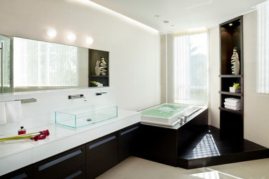 Modernes Badezimmer mit Aufsatzwaschbecken, dunklen Holzschränken und Badewanne in Nische in Miami