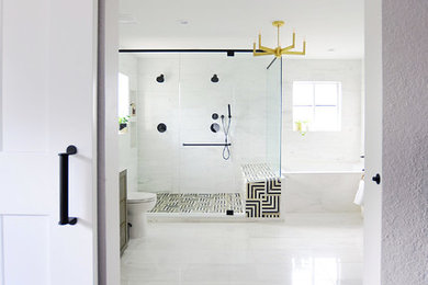 This is an example of a large modern ensuite bathroom in Other with freestanding cabinets, medium wood cabinets, a built-in bath, a double shower, a one-piece toilet, white tiles, porcelain tiles, white walls, porcelain flooring, a console sink, marble worktops, white floors, a sliding door and white worktops.