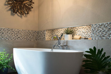 Идея дизайна: главная ванная комната среднего размера в современном стиле с плоскими фасадами, серыми фасадами, отдельно стоящей ванной, двойным душем, раздельным унитазом, серой плиткой, керамогранитной плиткой, серыми стенами, полом из винила, настольной раковиной и столешницей из искусственного кварца