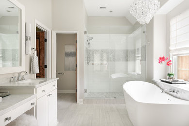 ヒューストンにあるトランジショナルスタイルのおしゃれな浴室 (シェーカースタイル扉のキャビネット、白いキャビネット、置き型浴槽、アルコーブ型シャワー、白いタイル、グレーの壁、グレーの床、開き戸のシャワー、グレーの洗面カウンター) の写真