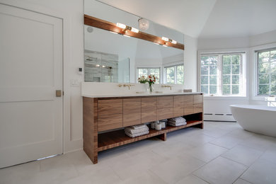 Large contemporary bathroom in Philadelphia with flat-panel cabinets, light wood cabinets, a freestanding bath, an alcove shower, white walls and a submerged sink.
