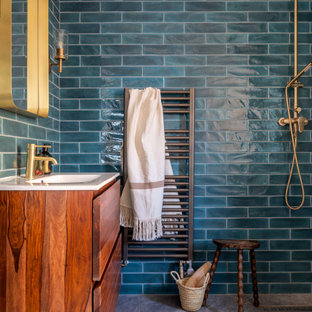 Contemporary bathroom in London with flat-panel cabinets, dark wood cabinets, a built-in shower, blue tiles, metro tiles, an integrated sink, grey floors, an open shower, white worktops, a single sink and a freestanding vanity unit.