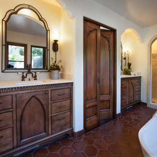 Idee per una grande stanza da bagno padronale mediterranea con lavabo sottopiano, ante con riquadro incassato, ante in legno bruno, top in pietra calcarea, vasca freestanding, doccia alcova, WC a due pezzi, piastrelle beige, piastrelle in terracotta, pareti bianche e pavimento in terracotta