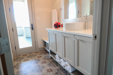 Large tuscan kids' gray tile and cement tile cement tile floor and gray floor walk-in shower photo in Austin with shaker cabinets, white cabinets, a two-piece toilet, white walls, a vessel sink, quartz countertops and a hinged shower door