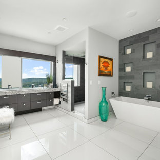 This is an example of a large contemporary master bathroom in Other with flat-panel cabinets, a freestanding tub, a trough sink, recycled glass benchtops, an open shower, multi-coloured benchtops, a double vanity, a floating vanity, grey cabinets, an alcove shower, gray tile, grey walls and white floor.