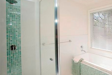 Foto de cuarto de baño principal contemporáneo con lavabo integrado, puertas de armario blancas, bañera exenta, ducha esquinera, sanitario de una pieza, baldosas y/o azulejos en mosaico, paredes blancas y suelo de baldosas de cerámica