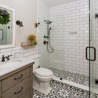 Idée de décoration pour une petit salle de bain champêtre avec un mur gris, un placard en trompe-l'oeil, des portes de placard marrons, un carrelage blanc, des carreaux de porcelaine, un sol en carreaux de ciment, un plan vasque, un plan de toilette en marbre, un sol multicolore, une cabine de douche à porte battante et un plan de toilette blanc.