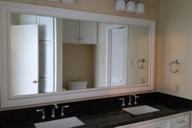 ヒューストンにある高級な中くらいなトラディショナルスタイルのおしゃれなマスターバスルーム (フラットパネル扉のキャビネット、白いキャビネット、ベージュの壁、アンダーカウンター洗面器、御影石の洗面台) の写真