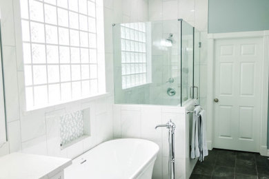 Cette image montre une grande salle de bain principale traditionnelle avec un placard avec porte à panneau encastré, des portes de placard blanches, une baignoire indépendante, une douche d'angle, un carrelage blanc, des carreaux de céramique, un mur vert, un sol en carrelage de céramique, un lavabo posé, un plan de toilette en quartz modifié, un sol gris, une cabine de douche à porte battante, un plan de toilette blanc, meuble simple vasque et meuble-lavabo encastré.