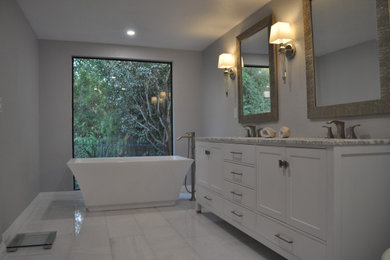 Example of a transitional white tile and porcelain tile marble floor, white floor and double-sink bathroom design in Los Angeles with recessed-panel cabinets, white cabinets, a one-piece toilet, gray walls, an undermount sink, granite countertops, white countertops and a freestanding vanity