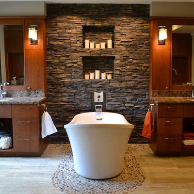 Example of a trendy pebble tile floor freestanding bathtub design in Cedar Rapids with flat-panel cabinets and dark wood cabinets