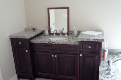 Ejemplo de cuarto de baño tradicional con armarios tipo mueble, puertas de armario de madera en tonos medios y encimera de granito