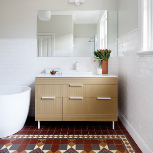 Inspiration for an eclectic bathroom in Sydney with furniture-like cabinets, a freestanding tub, white tile, ceramic tile, cement tiles, a drop-in sink, engineered quartz benchtops, multi-coloured floor, white benchtops, beige cabinets and beige walls.