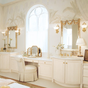Modelo de cuarto de baño principal, clásico, grande, con paredes beige, lavabo bajoencimera, armarios con paneles con relieve, encimera de acrílico y puertas de armario beige