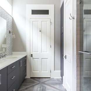 Mid-sized transitional master medium tone wood floor and gray floor alcove shower photo in New Orleans with flat-panel cabinets, gray cabinets, gray walls, an undermount sink, quartz countertops, a hinged shower door and white countertops