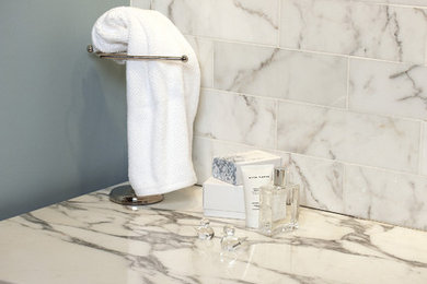 Imagen de cuarto de baño principal clásico renovado con puertas de armario de madera en tonos medios, baldosas y/o azulejos blancos, paredes azules y encimera de mármol