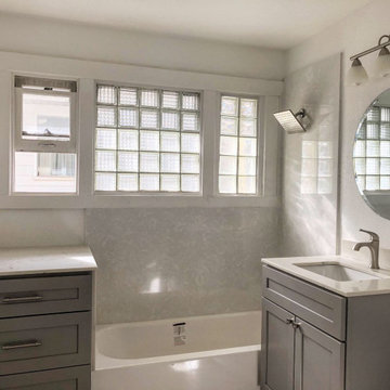 Stone covered cabinet next to tub