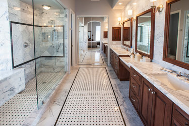 Klassisches Badezimmer mit profilierten Schrankfronten, dunklen Holzschränken, Marmor-Waschbecken/Waschtisch, offener Dusche, grauen Fliesen, Steinfliesen und offener Dusche in Phoenix