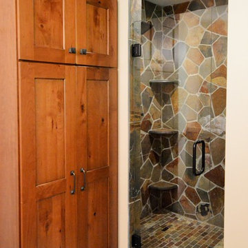 Stone shower with seating and armoir style cabinet