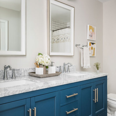 Inspiration for a large timeless kids' white tile and porcelain tile porcelain tile and gray floor bathroom remodel in Charlotte with shaker cabinets, blue cabinets, a two-piece toilet, gray walls, an undermount sink, marble countertops and gray countertops