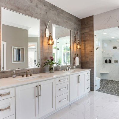 Example of a transitional master wood-look tile marble floor, multicolored floor and double-sink bathroom design in Raleigh with shaker cabinets, white cabinets, an undermount sink, quartz countertops, a hinged shower door, white countertops, a niche and a built-in vanity