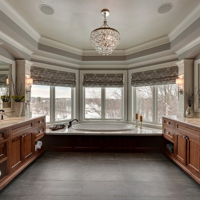 Drop-in bathtub - traditional black tile drop-in bathtub idea in Minneapolis with an undermount sink and dark wood cabinets